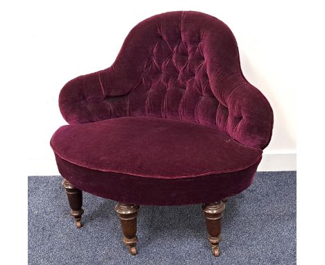 EDWARDIAN PARLOUR ARMCHAIRwith a shaped button back above a stuffover seat, covered in a purple velvet, standing on three tur