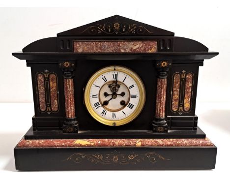 VICTORIAN BLACK SLATE AND MARBLE MANTEL CLOCKof architectural outline with a circular brass and enamel dial with Roman numera