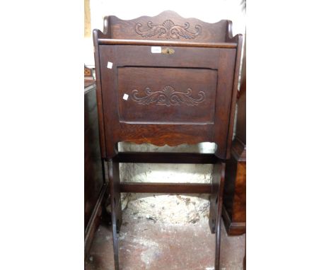 A 61cm early 20th Century stained oak student's bureau with carved decoration, part fitted interior and folding bracket stand
