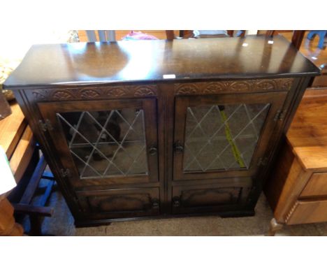 A 1.06m late 20th Century polished oak book cabinet in the antique style with pair of leaded glazed panel doors over double c