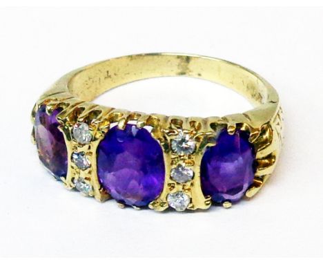 A marked 18ct yellow metal ring, set with three oval amethysts interspersed with six small brilliant cut diamonds