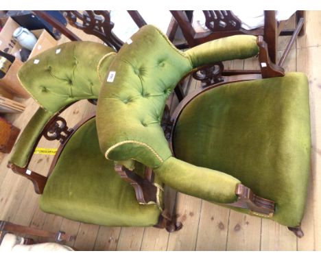 A pair of late Victorian walnut part show frame tub elbow chairs with green button back upholstery and decorative triple pier