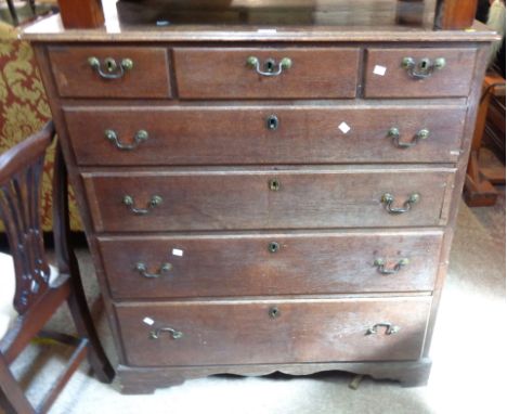 A 1.04m Georgian oak chest of three short drawers over four long graduated drawers, set on bracket feet - age related wear an