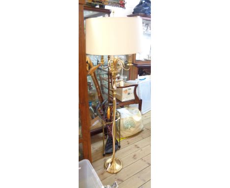 An ornate brass three branch standard lamp with foliage to top and slender reeded pillar with shade