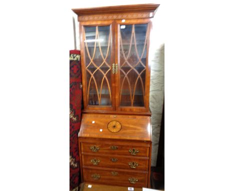 An 87cm reproduction mahogany bureau bookcase by Bassett Furniture with blind fretwork decoration to glazed top over part fit