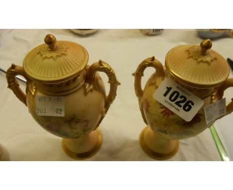 A pair of Royal Worcester blush ivory covered two-handled vases, each decorated with floral sprays