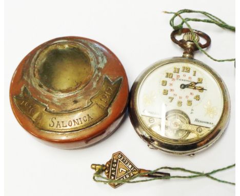 A French steel cased Hebdomas pocket watch with decorative dial and visible escapement, contained within a First World War pe