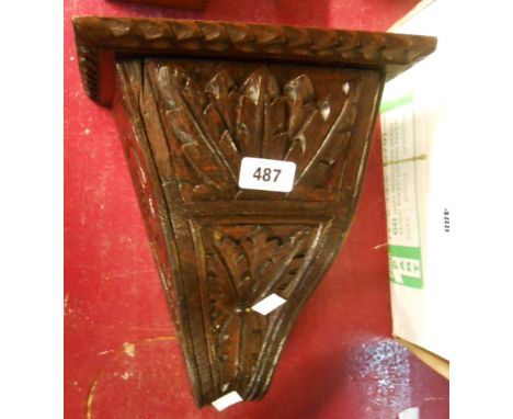 A carved and stained oak wall bracket