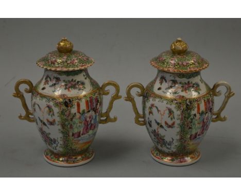 A PAIR OF CANTON LIDDED VASES, with quatrefoil section body decorated in polychrome enamels with figures in domestic scenes, 