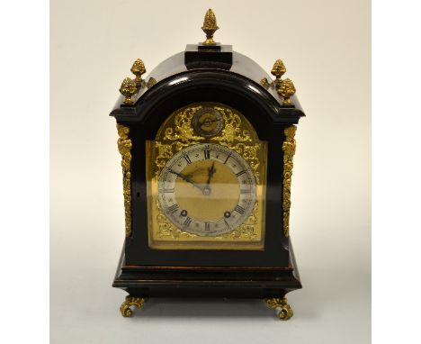 A GERMAN EBONISED BRACKET CLOCK, with dome top, ormolu corner mounts moulded as garlands with mask head top set on scroll fee