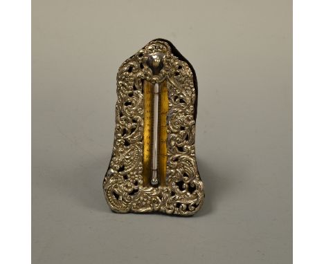 A SILVER EASEL DESK THERMOMETER, with pierced embossed scroll and floral design with vacant cartouche to top, Chester 1900, a