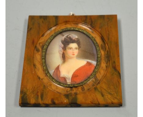 AN OVAL PORTRAIT MINIATURE, depicting seated woman in red gown and head dress, signed Heltek bottom left, set in faux tortois