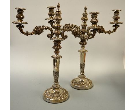 A PAIR OF PLATED THREE BRANCH CANDELABRA, with embossed floral decoration to two branches and central urn moulding and flame 