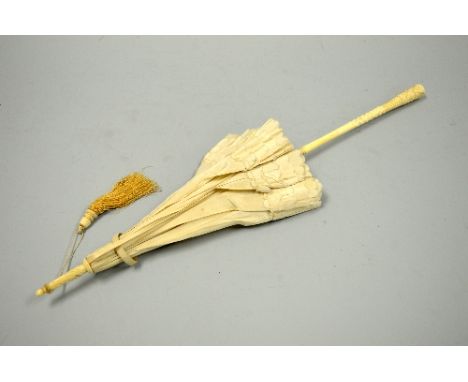A VINTAGE PARASOL, with carved floral bone handle and tapering bone finial to cream silk and with tassel, length approximatel