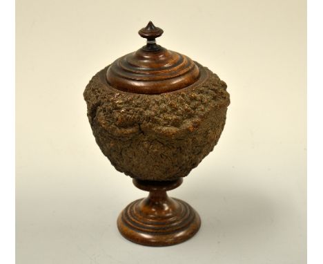 A LIDDED SAPUCAIA TOBACCO JAR, of urn form on turned circular foot and shaped lid with urn finial, approximately 27cm high