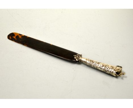 A WHITE METAL MOUNTED TORTOISESHELL PAGE TURNER, with embossed figural handle and dog finial, approximately 32.5 cm long (bla