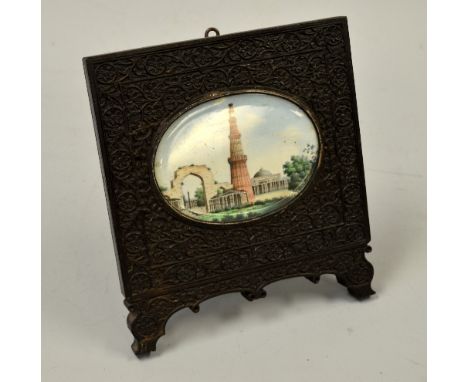 AN OVAL LANDSCAPE MUGHAL MINIATURE, depicting buildings and trees set in carved hardwood easel frame, approximately 11.5cm x 