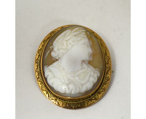 A SHELL CAMEO BROOCH, of two Roman figures in profile, with harp in the foreground with cloud surround