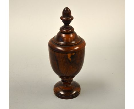 A 19TH CENTURY LIGNUM VITAE CUP AND COVER, of urn form with acorn finial on circular foot, approximately 27cm high