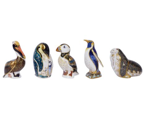 Two Royal Crown Derby paperweights of penguins and others the first standing penguin feeding its chick, the second emperor pe