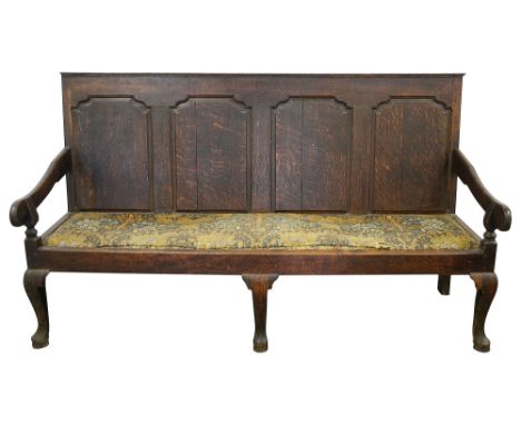 A George III oak settle plain top rail over a four fielded panel back with ogee top corners, with downswept arms and upholste