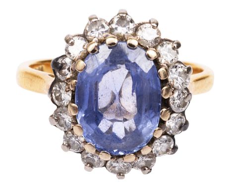 A sapphire and diamond-set cluster ringthe oval sapphire set above a surround of brilliant-cut diamonds to the plain tapering