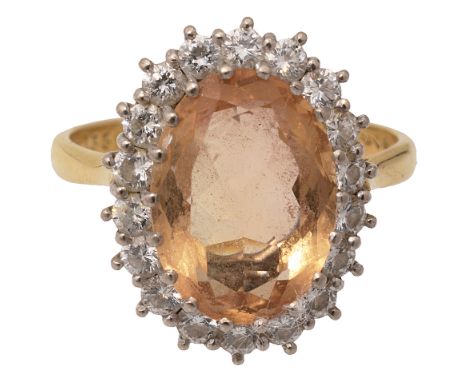 A topaz and diamond-set cluster ringthe oval mixed-cut topaz within a surround of brilliant-cut diamonds to the plain taperin