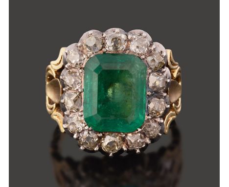 A 19th century emerald and diamond-set cluster ring, the rectangular cut-cornered emerald estimated to weigh 3.3 cts to the o