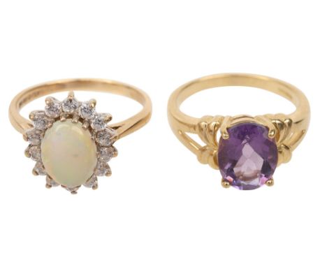 Two gem-set and 9ct yellow gold rings:  an oval opal cabochon within a white stone border, London hallmark; and a oval amethy