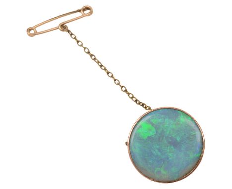 A circular opal brooch,  the peacock blue and green opal (possibly a doublet) within a collet and closed back setting stamped