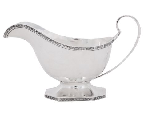 A George V silver sauce boatSheffield, 1929 by Walker Hall, of plain typical form with scroll handle and foliate borders and 