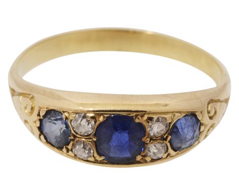 A sapphire and diamond-set ring,the three sapphires each separated by two old brilliant-cut diamonds recessed within scrollin