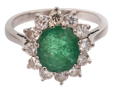 An emerald and diamond-set cluster ring, the oval mixed-cut emerald within a surround of twelve brilliant-cut diamonds, baske