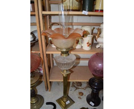 OIL LAMP WITH BRASS COLUMN BASE, CLEAR GLASS FONT AND A FRILLED TINTED SHADE