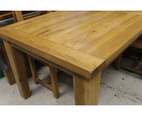 A light oak extending rectangular dining table on square section legs, together with six ladder back chairs