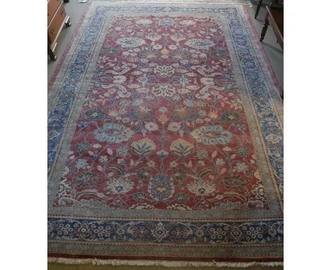 A Ziegler designed carpet, the central panel set with all-over floral design on a red ground, within a stepped red, blue and 