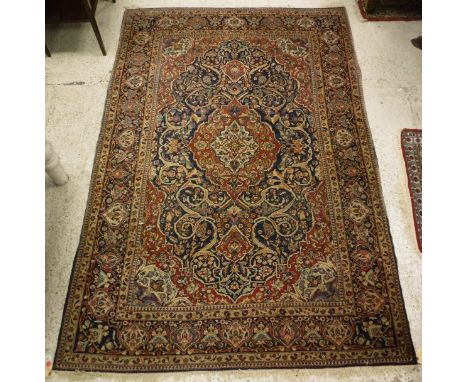An Iraqi rug, the central panel set with floral decorated medallion on a red and blue ground with all-over floral decoration,