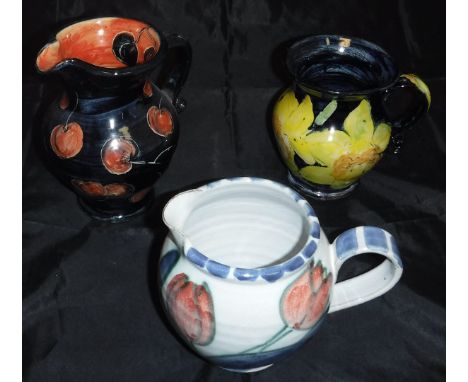 A collection of Rosie Jackson pottery comprising two jugs, one decorated with cherries, the other with tulips, two floral dec