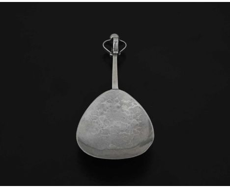 A. E. Jones, a George V silver Arts and Crafts caddy spoon, with a spot-hammered fig-shaped bowl, the terminal with applied s