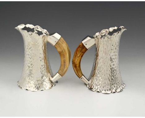 Hukin and Heath, a pair of plated pitchers, the flared cylindrical bodies with textured decoration, each with a flat cover se