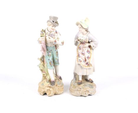 Pair of porcelain figures of a lady and a gentleman carrying a bouquet. Crossed swords and R mark to base. Max H38.5cm