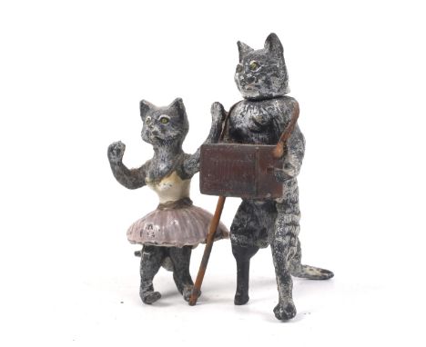 An Austrian cold painted and enamelled lead group of cats. One cat as a ballet dancer, the other with a peg-leg, playing an a