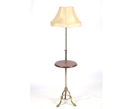 An early 20th century telescopic table lamp. The brass tripod frame featuring a circular mahogany shelf, topped with a cream 