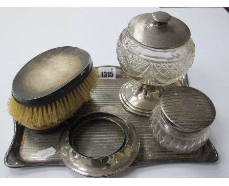 A Silver Lidded Tidy Jar, engine turned silver backed hair brushes, silver topped and based pedestal jar, plated tray.