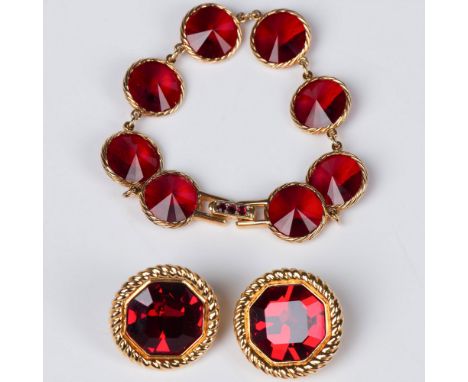 The bracelet has deep rich ruby colored round faceted stones surrounded by a gold rope style edge. The round stones are linke