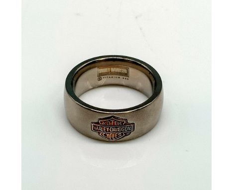 Copper tone sterling silver Harley Davidson logo on a silver tone titanium band with satin finish. Titanium and 925 stamped i