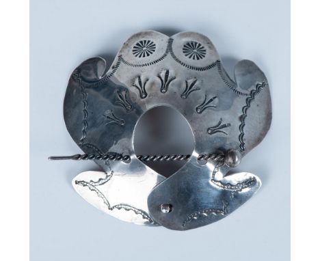 The cuff has a stamped tribal design and secures with a small button and twisted pin. It measures approximately 3"L x 3.25"W,