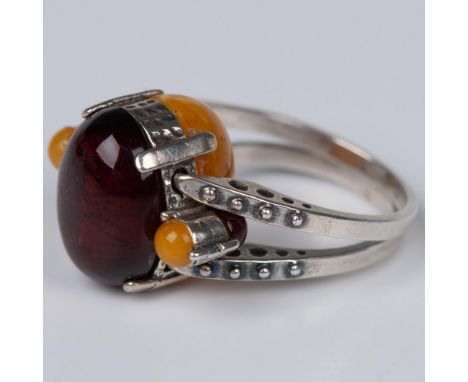 Extraordinary ring with cherry and butterscotch amber cabochon stones. The sterling silver band flips around to give you an e