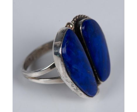 Two uniquely shaped pieces of rich blue lapis are surrounded by an artistic design of sterling silver to create this beautifu