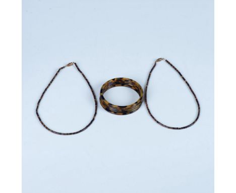 The two simple and sleek brown shell bugle bead necklaces have copper color screw back closures. The five faux tortoise shell